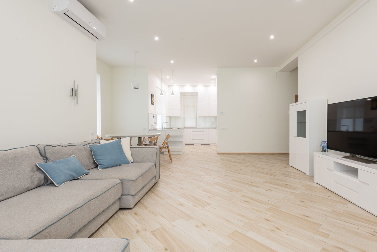 Modern apartment with spacious lounge with television and clean new laminate under bright luminous lights